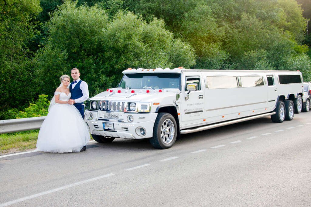 laimingi jaunieji ant kelio prie vieno didžiausio ir ilgiausio limuzino Lietuvoje