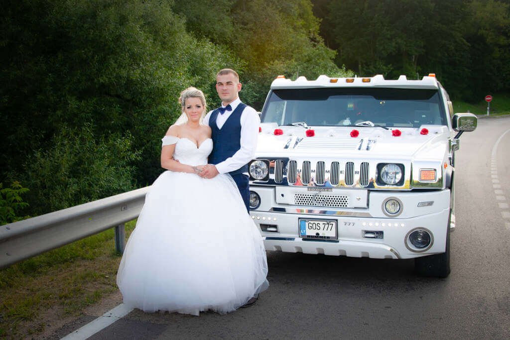 laimingi jaunieji kelyje prie vieno didžiausio ir ilgiausio limuzino Lietuvoje