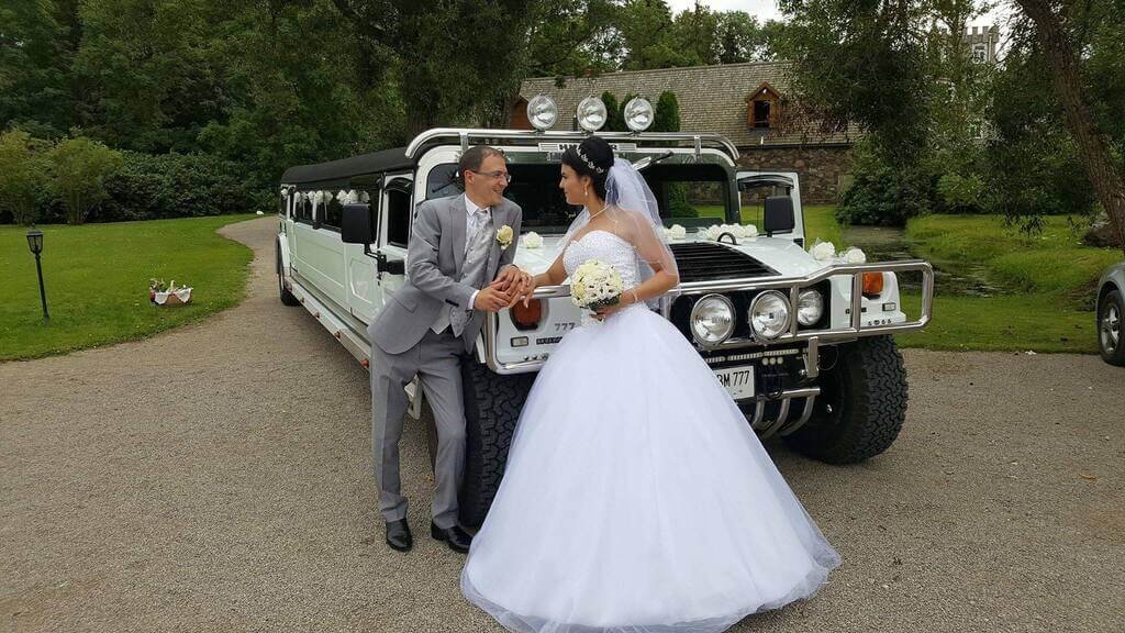 laimingi jaunieji prie įspūdingo karinio limuzino