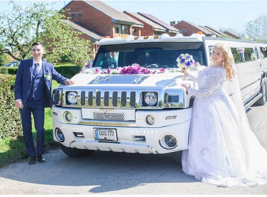 laimingi jaunieji prie vieno didžiausio ir ilgiausio limuzino Lietuvoje