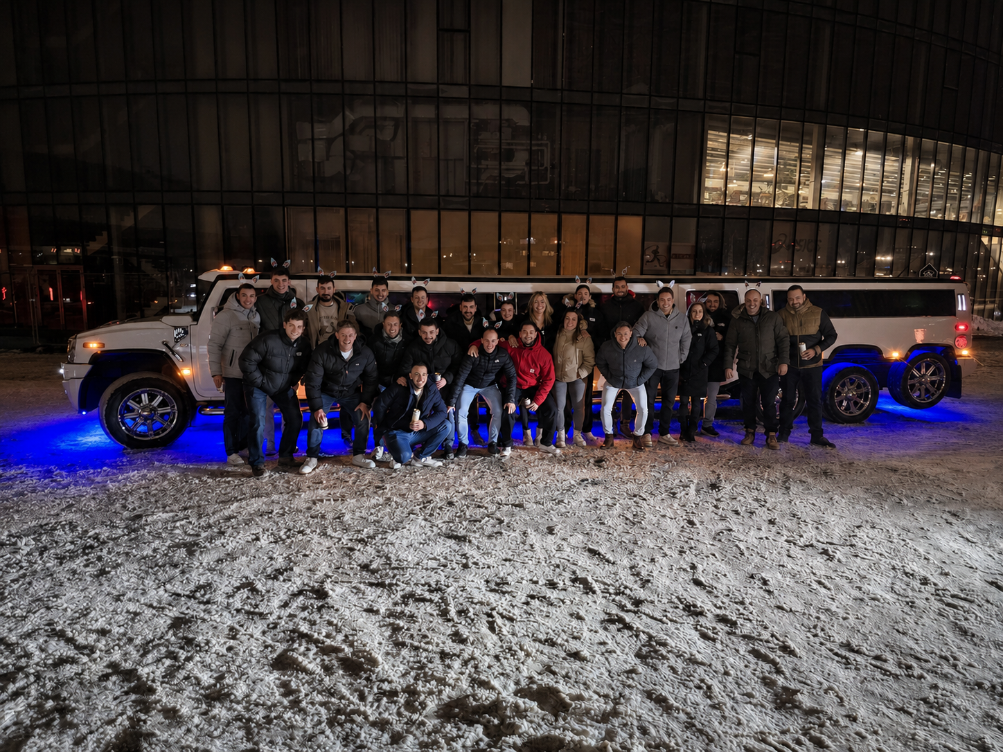 Renginio dalyvių grupė prie balto Hummer limuzino